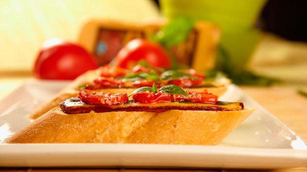 Bruschetta con tomate, queso tilsit ahumado y albahaca